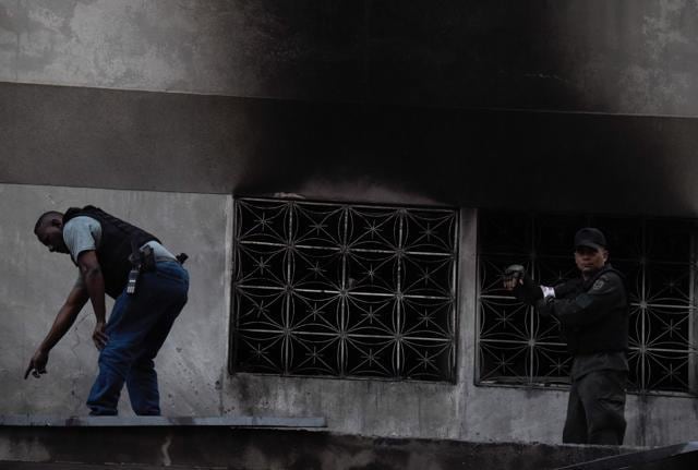 Security forces check a building after an explosion was heard during a ceremony attended by Venezuelan President Nicolas Maduro in support of the National Guard in Caracas on August 4, 2018. (AFP) Security forces check a building after an explosion was heard during a ceremony attended by Venezuelan President Nicolas Maduro in support of the National Guard in Caracas on August 4, 2018. (AFP)