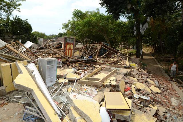 A man (R) walks past collapsed houses in Kayangan in northern Lombok island on August 9, 2018, following the August 5 earthquake. (AFP) A man (R) walks past collapsed houses in Kayangan in northern Lombok island on August 9, 2018, following the August 5 earthquake. (AFP)