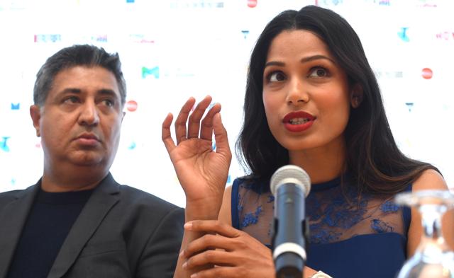Indian film director Tabrez Noorani (L) answers questions with Bollywood and Hollywood actor Freida Pinto (R) during a press conference. (AFP)