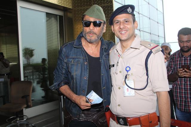 Jackie Shroff poses with security staff at the airport.