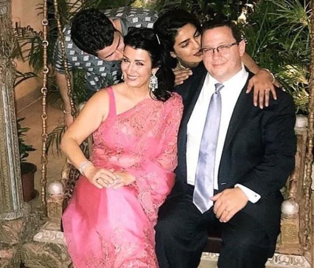 Nick Jonas and Priyanka Chopra kissing his parents at the engagement party.