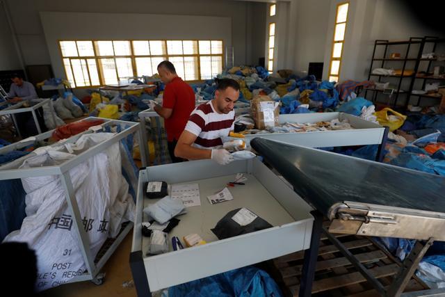 A Palestinian worker arranges items sent by mail eight years ago, after Israel allowed the letters and goods into the West Bank from Jordan, where they were being held, Jericho, in the occupied West Bank on August 19. (REUTERS) A Palestinian worker arranges items sent by mail eight years ago, after Israel allowed the letters and goods into the West Bank from Jordan, where they were being held, Jericho, in the occupied West Bank on August 19. (REUTERS)