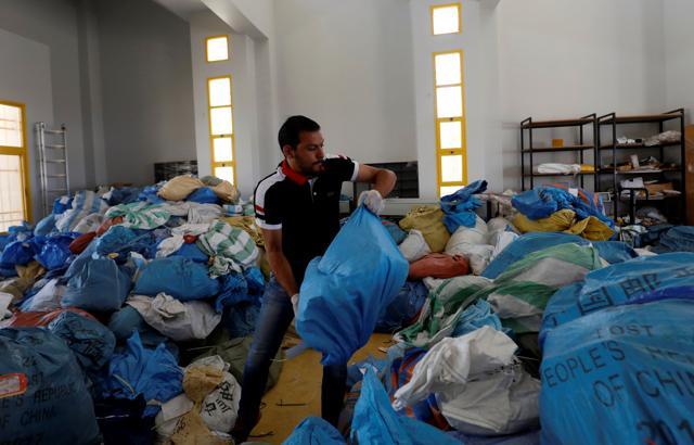 A Palestinian worker carries a bag containing items sent by mail eight years ago, after Israel allowed the letters and goods into the West Bank from Jordan, where they were being held, Jericho, in the occupied West Bank on August 19. (REUTERS) A Palestinian worker carries a bag containing items sent by mail eight years ago, after Israel allowed the letters and goods into the West Bank from Jordan, where they were being held, Jericho, in the occupied West Bank on August 19. (REUTERS)