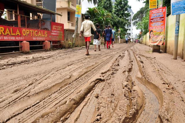 People walk along a muddy road in Kochi. (AFP)