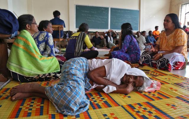 Flood victims rest inside a university classroom, which is converted into a temporary relief camp in Kochi in Kerala. (REUTERS)