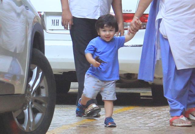 Taimur Ali Khan smiles at cameras.