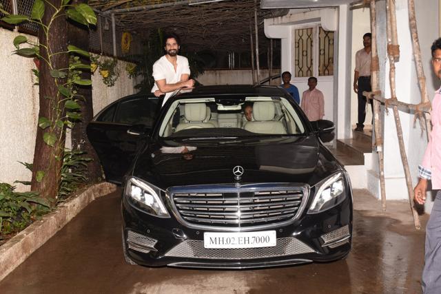 Shahid Kapoor waves to the camera, half hanging from his Mercedes.
