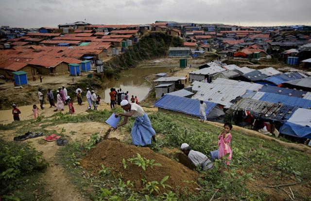 In this Aug. 22, 2018 photo, a young Rohingya refugee girl stands near elders digging a fresh grave at a cemetery in Kutupalong refugee camp, a ramshackle sprawl of camps built amid low rolling hills and endless monsoon-season mud, in Bangladesh. (AP) In this Aug. 22, 2018 photo, a young Rohingya refugee girl stands near elders digging a fresh grave at a cemetery in Kutupalong refugee camp, a ramshackle sprawl of camps built amid low rolling hills and endless monsoon-season mud, in Bangladesh. (AP)