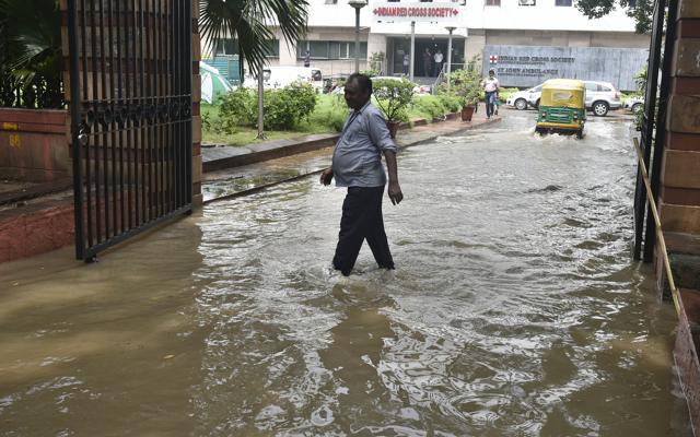 A man wades through a waterlogged road at Indian Red Cross building, opposite Parliament House, in New Delhi, on Tuesday. (Raj K Raj/HT Photo) A man wades through a waterlogged road at Indian Red Cross building, opposite Parliament House, in New Delhi, on Tuesday. (Raj K Raj/HT Photo)