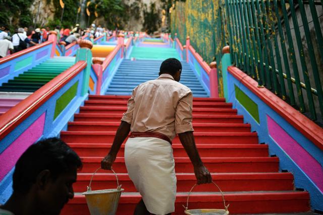A worker walks up the newly-painted 272-steps staircase leading to Malaysia's Batu Caves temple in Kuala Lumpur on August 30, 2018. (AFP) A worker walks up the newly-painted 272-steps staircase leading to Malaysia's Batu Caves temple in Kuala Lumpur on August 30, 2018. (AFP)