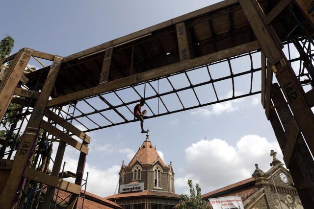 A worker climbs on the wooden arch which is a part of the decorations of Mahatma Phule Mandai Ganapati on Wednesday. (Rahul Raut/HT) A worker climbs on the wooden arch which is a part of the decorations of Mahatma Phule Mandai Ganapati on Wednesday. (Rahul Raut/HT)