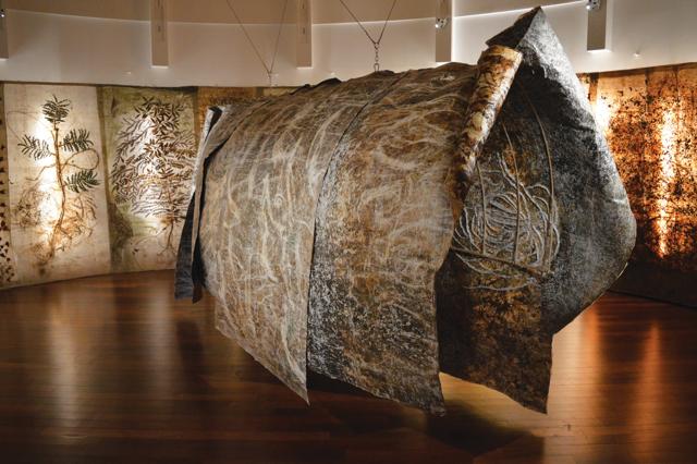 In the centre of the space, scrolls laid over a ribbed armature create a cocoon. Visitors can walk through to discover tiny insect forms created on its surface with sequins and glitter.