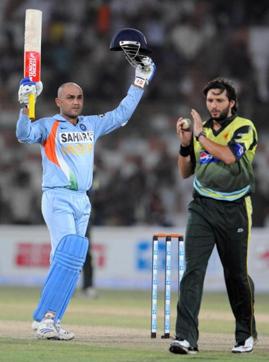 Indian cricketer Virender Sehwag (L) raises his bat and helmet after he scored a century (100 runs) as Pakistani cricketer Shahid Afridi coagulates to him during a Group B match between Pakistan and India at the National Cricket Stadium in Karachi on June 26, 2008. (AFP/Getty Images) Indian cricketer Virender Sehwag (L) raises his bat and helmet after he scored a century (100 runs) as Pakistani cricketer Shahid Afridi coagulates to him during a Group B match between Pakistan and India at the National Cricket Stadium in Karachi on June 26, 2008. (AFP/Getty Images)