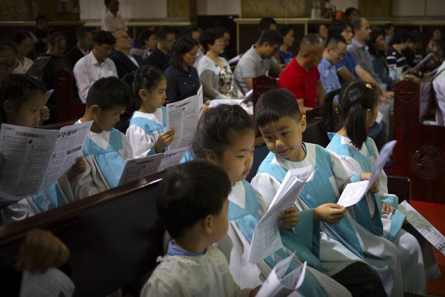 Children look at a church bulletin during a mass at the Cathedral of the Immaculate Conception, a government-sanctioned Catholic church in Beijing, Saturday, Sept. 22, 2018. (AP) Children look at a church bulletin during a mass at the Cathedral of the Immaculate Conception, a government-sanctioned Catholic church in Beijing, Saturday, Sept. 22, 2018. (AP)