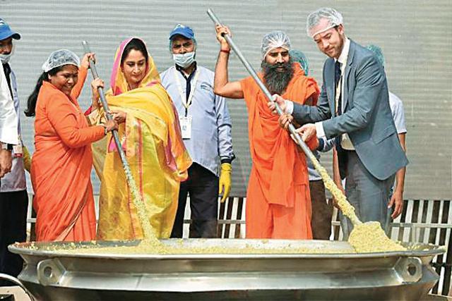 Union Cabinet minister of food processing Harsimrat Kaur Badal and Baba Ramdev cooking khichri at the World Food India festival Union Cabinet minister of food processing Harsimrat Kaur Badal and Baba Ramdev cooking khichri at the World Food India festival