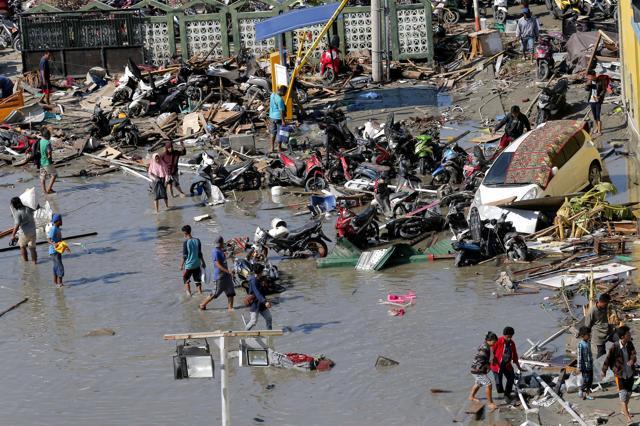People survey outside the shopping mall which was damaged following earthquakes and a tsunami in Palu, Central Sulawesi, Indonesia. (AP Photo) People survey outside the shopping mall which was damaged following earthquakes and a tsunami in Palu, Central Sulawesi, Indonesia. (AP Photo)