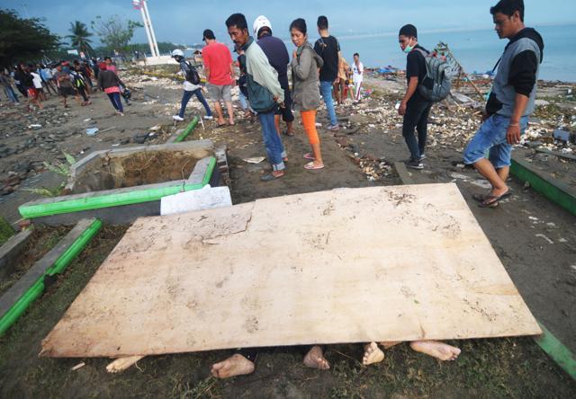 Residents look at covered up bodies recovered after an earthquake and tsunami hit Palu, on Sulawesi island. (AFP Photo) Residents look at covered up bodies recovered after an earthquake and tsunami hit Palu, on Sulawesi island. (AFP Photo)