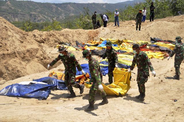 Indonesian soldiers line up the bodies of tsunami and earthquake victims for a mass burial in Palu, Central Sulawesi, Indonesia on October 2, 2018. (AP Photo) Indonesian soldiers line up the bodies of tsunami and earthquake victims for a mass burial in Palu, Central Sulawesi, Indonesia on October 2, 2018. (AP Photo)