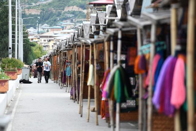 Tourist walk past stalls at Nozrin Lam local market in the Bhutanese capital Thimphu. (AFP Photo) Tourist walk past stalls at Nozrin Lam local market in the Bhutanese capital Thimphu. (AFP Photo)