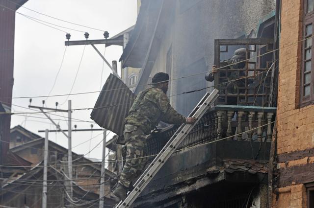 Policemen enter a house where militants were hiding during an encounter between security forces and militants in downtown Srinagar on Wednesday. (Waseem Andrabi/HT) Policemen enter a house where militants were hiding during an encounter between security forces and militants in downtown Srinagar on Wednesday. (Waseem Andrabi/HT)