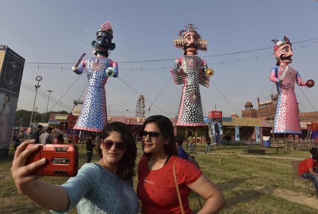 Visitors click selfie with the effigies of demon king Ravana and his son Meghnath and brother Kumbhkaran installed ahead of Dussehra festival at Nav Shri Dharmik Leela Committee, Red Fort, in New Delhi. (Sanjeev Verma/HT PHOTO)