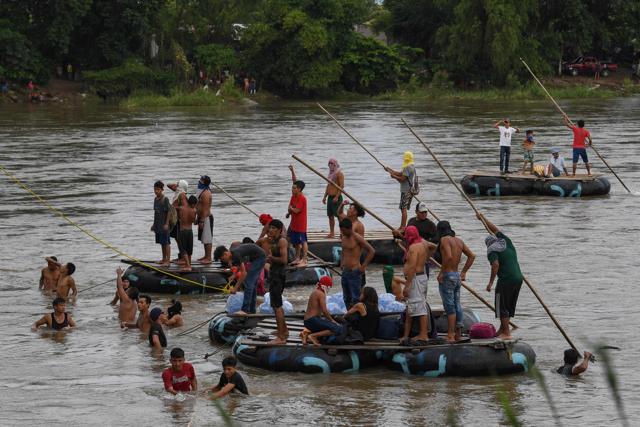 Honduran migrants heading in a caravan to de US, await for fellow migrants to jump from the Guatemala-Mexico international border bridge into the Suchiate river, to swim or board a raft to reach Mexico. (AFP Photo) Honduran migrants heading in a caravan to de US, await for fellow migrants to jump from the Guatemala-Mexico international border bridge into the Suchiate river, to swim or board a raft to reach Mexico. (AFP Photo)