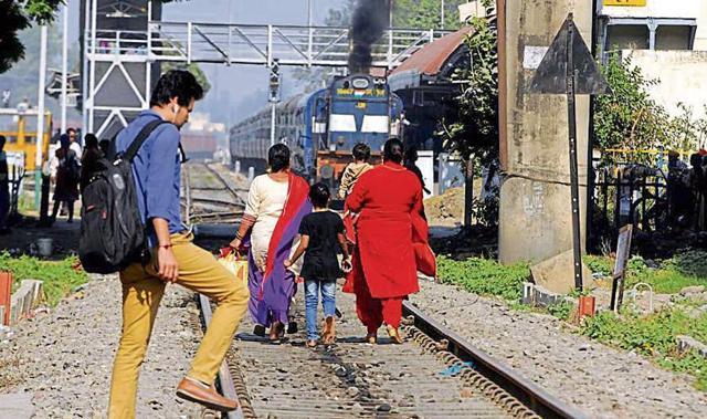 A family with children in tow walking on the track as a train approaches and a youngster with ears plugged in Patiala on Thursday are examples of irresponsible civic behaviour. (HT Photo) A family with children in tow walking on the track as a train approaches and a youngster with ears plugged in Patiala on Thursday are examples of irresponsible civic behaviour. (HT Photo)