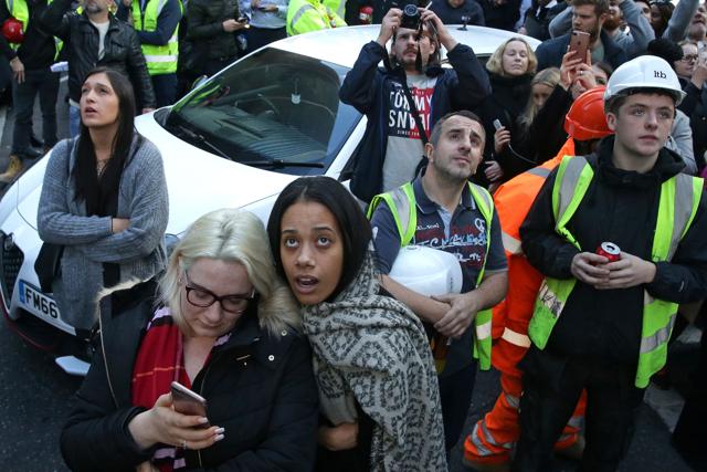 Passers-by look up at French urban climber Alain Robert climbing Heron. (AFP) Passers-by look up at French urban climber Alain Robert climbing Heron. (AFP)