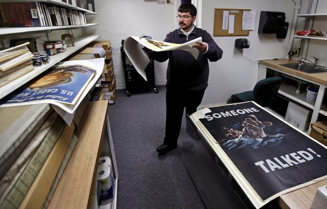 Brian Sylvester, director of the Rochester Public Library, carries an original war poster at the library's archive in Rochester. (AP) Brian Sylvester, director of the Rochester Public Library, carries an original war poster at the library's archive in Rochester. (AP)