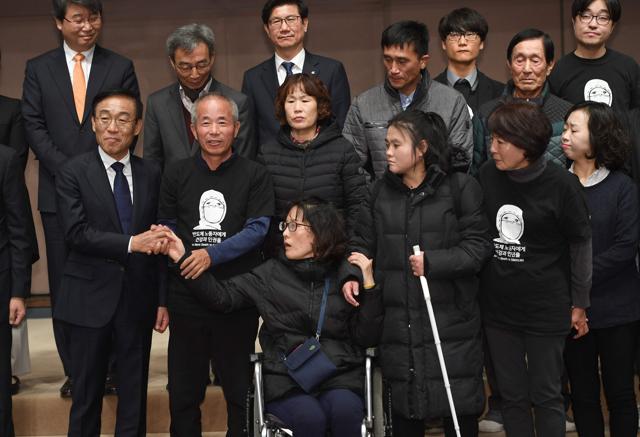 Samsung Electronics co-president Kim Ki-nam (L) poses for a photo with relatives of victims of work-related diseases of its semiconductor and LCD factories after he made a formal apology in Seoul. (AFP) Samsung Electronics co-president Kim Ki-nam (L) poses for a photo with relatives of victims of work-related diseases of its semiconductor and LCD factories after he made a formal apology in Seoul. (AFP)