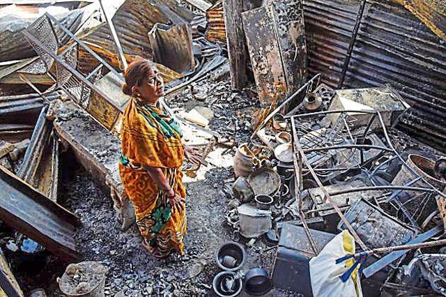 A woman looks in despair at her burnt-down shanty and belongings at the Patil estate slums on Thursday. (Photo Sanket Wankhade/HT PHOTO)