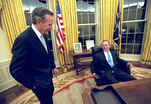 US President George W. Bush sits at his desk in the Oval Office for the first time on Inauguration Day as his father, former President George HW Bush, looks on January 20, 2001. (Reuters File Photo) US President George W. Bush sits at his desk in the Oval Office for the first time on Inauguration Day as his father, former President George HW Bush, looks on January 20, 2001. (Reuters File Photo)