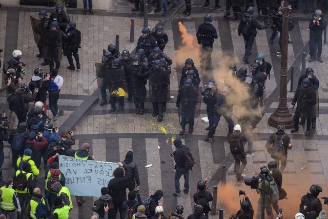 Riot police face yellow vest (gilet jaune) protestors on December 8, 2018 near the Arc de Triomphe in Paris during a protest against rising costs of living they blame on high taxes. (AFP) Riot police face yellow vest (gilet jaune) protestors on December 8, 2018 near the Arc de Triomphe in Paris during a protest against rising costs of living they blame on high taxes. (AFP)