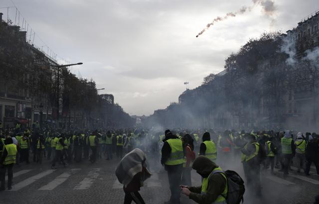 A tear gas canister is to hit the Champs-Elysees avenue where yellow vests demonstrators march Saturday. Crowds of yellow-vested protesters angry at President Emmanuel Macron and Frances high taxes tried to march Saturday on the presidential palace, surrounded by exceptional numbers of police bracing for outbreaks of violence after the worst rioting in Paris in decades. (AP) A tear gas canister is to hit the Champs-Elysees avenue where yellow vests demonstrators march Saturday. Crowds of yellow-vested protesters angry at President Emmanuel Macron and Frances high taxes tried to march Saturday on the presidential palace, surrounded by exceptional numbers of police bracing for outbreaks of violence after the worst rioting in Paris in decades. (AP)