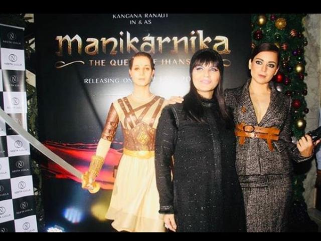 On display is a Manikarnika figurine as Kangana and Neeta Lulla pose.