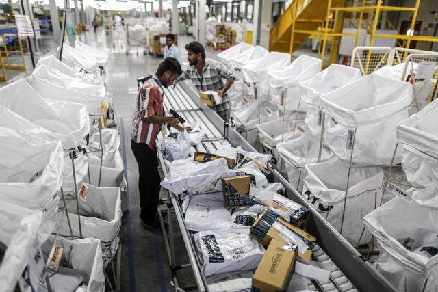An employee uses a scanner as he prepares a package for shipment at the Amazon.com Inc fulfillment center in Hyderabad, India. Photographer: Dhiraj Singh/Bloomberg (Bloomberg) An employee uses a scanner as he prepares a package for shipment at the Amazon.com Inc fulfillment center in Hyderabad, India. Photographer: Dhiraj Singh/Bloomberg (Bloomberg)