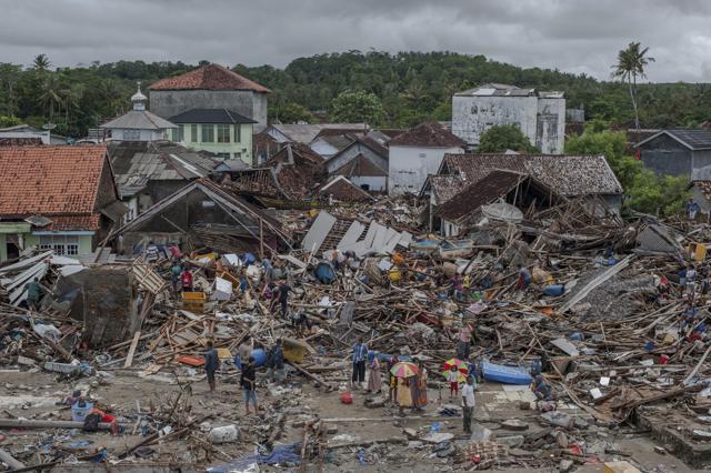 People inspect the damage at a tsunami-ravaged village in Sumur, Indonesia. Doctors are working to help survivors and rescuers are looking for more victims from a deadly tsunami that smashed into beachside buildings along an Indonesian strait. (AP File Photo) People inspect the damage at a tsunami-ravaged village in Sumur, Indonesia. Doctors are working to help survivors and rescuers are looking for more victims from a deadly tsunami that smashed into beachside buildings along an Indonesian strait. (AP File Photo)