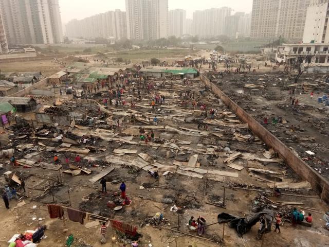 As many as 250 shanties were destroyed and over 1,000 men, women and children were left homeless in the cold after fire broke out in a dwelling of scrap dealers in Sarfabad village of Noida Sector 73 on Friday morning. (Virendra Singh Gosain/HT PHOTO)