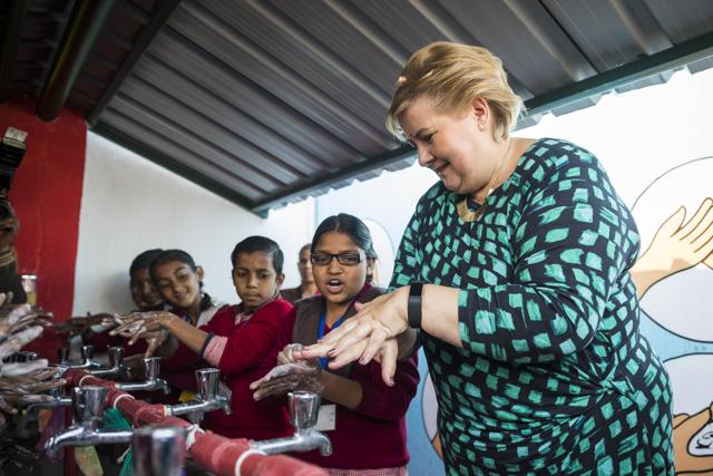 Norwegian Prime Minister Erna Solberg telling students how to wash hands at a primary school in Ghaziabad.