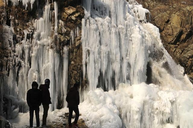 People click pictures of a frozen waterfall at Tangmarg, North Kashmir, December 27, 2018. (Waseem Andrabi / HT Photo )