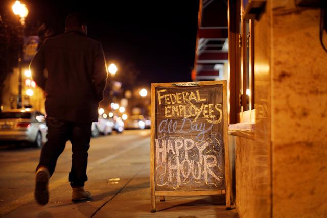 A sign the reads ‘Federal employees all day happy hour’ is displayed at a local bar as the partial US government shutdown enters its third week in Washington. (REUTERS) A sign the reads ‘Federal employees all day happy hour’ is displayed at a local bar as the partial US government shutdown enters its third week in Washington. (REUTERS)