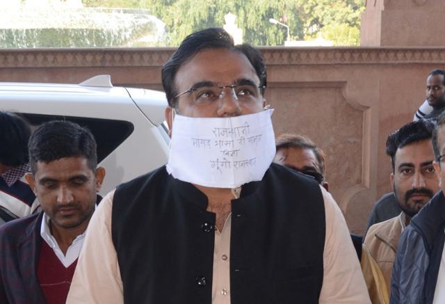 BJP MLA from Nokha, Biharilal Bishnoi arrived wearing a mask which had his demand of taking oath in Rajasthani written on it. (HT Photo ) BJP MLA from Nokha, Biharilal Bishnoi arrived wearing a mask which had his demand of taking oath in Rajasthani written on it. (HT Photo )