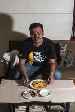 Frank D’Souza with his cats Lyra and Smarty, along with his Chicken Biryani and kebab ordered through a food delivery app, at his residence in Mumbai. (Aalok Soni / HT)