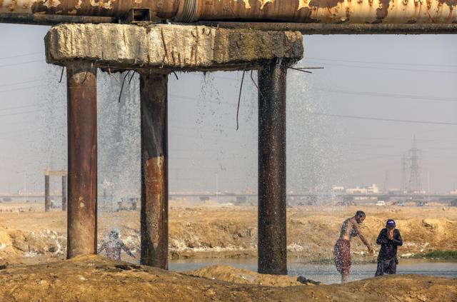 People bathe with water from a pipe leakage. Photographer: Asim Hafeez/Bloomberg (Bloomberg) People bathe with water from a pipe leakage. Photographer: Asim Hafeez/Bloomberg (Bloomberg)