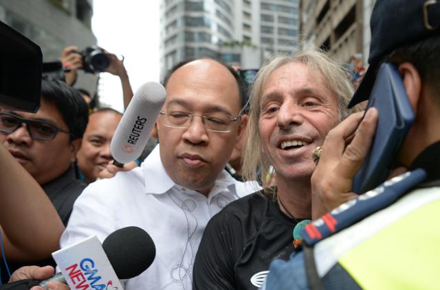 Alain Robert (centre R) accompanied by his lawyer Howard Calleja (centre L) while led to a police car after being detained following his climb. (AFP) Alain Robert (centre R) accompanied by his lawyer Howard Calleja (centre L) while led to a police car after being detained following his climb. (AFP)