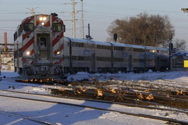 A Metra train moves southbound to downtown Chicago as the gas-fired switch heater on the rails keeps the ice and snow off the switches near Metra Western Avenue station in Chicago. (AP Photo/Kiichiro Sato) A Metra train moves southbound to downtown Chicago as the gas-fired switch heater on the rails keeps the ice and snow off the switches near Metra Western Avenue station in Chicago. (AP Photo/Kiichiro Sato)