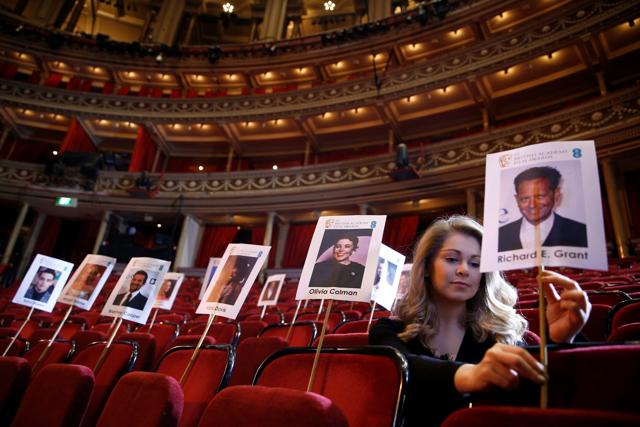 An assistant poses while positioning place sticks for guests during preparations for the British Academy of Film and Television Awards (BAFTA) ceremony at the Royal Opera House in central London. (REUTERS) An assistant poses while positioning place sticks for guests during preparations for the British Academy of Film and Television Awards (BAFTA) ceremony at the Royal Opera House in central London. (REUTERS)