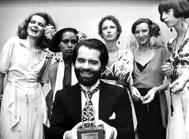 FILE -- In this Nov. 29, 1973 photo German fashion designer Karl Lagerfeld, left, poses with models in Krefeld, Germany. Chanel's iconic couturier, Karl Lagerfeld, whose accomplished designs as well as trademark white ponytail, high starched collars and dark enigmatic glasses dominated high fashion for the last 50 years, has died. He was around 85 years old. (Willi Bertram/dpa via AP, file) (AP) FILE -- In this Nov. 29, 1973 photo German fashion designer Karl Lagerfeld, left, poses with models in Krefeld, Germany. Chanel's iconic couturier, Karl Lagerfeld, whose accomplished designs as well as trademark white ponytail, high starched collars and dark enigmatic glasses dominated high fashion for the last 50 years, has died. He was around 85 years old. (Willi Bertram/dpa via AP, file) (AP)