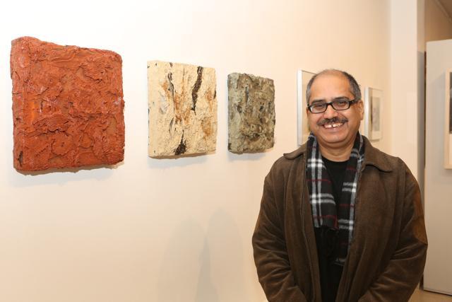 Artist Satish Sharma with his works on display at the exhibition. (Prabhas Roy/HT)