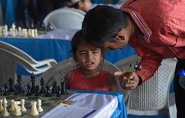 Poorvi Lathi reacts before her match while her father talks to her during Maharashtra state selection under-7 girls and boys chess championship, Khed Shivapur on Friday. (Pratham Gokhale/HT Photo)